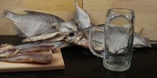一个盛满啤酒的玻璃杯，背景是鳕鱼