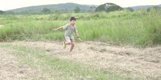 一个小男孩在夏日的草地上奔跑