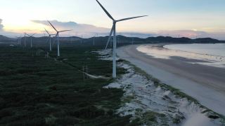 无人机拍摄的海滩上的风力发电场视频素材模板下载