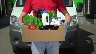 志愿者拿着盛有食物的盒子，社会救助。特写男子手拿捐赠蔬菜的盒子视频素材模板下载