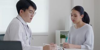 亚洲友好的医生在医院办公室谈论建议病人。