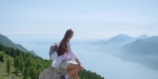 一个小女孩坐在加尔达湖前的山上
