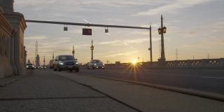 通勤者开车经过太阳升起的高清桥