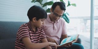 十几岁的男孩和他的父亲在家里学习