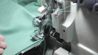 钑骨缝纫机。一个专业裁缝的手在做裁缝。自动化纺织工业缝纫机视频素材模板下载
