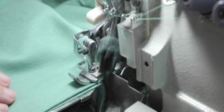 钑骨缝纫机。一个专业裁缝的手在做裁缝。自动化纺织工业缝纫机