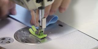 一个裁缝的手在缝纫机上缝制衣服的细节。工作室。特写镜头