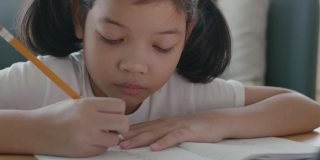 亚洲小女孩在平板电脑上通过互联网家教做作业和在线学习
