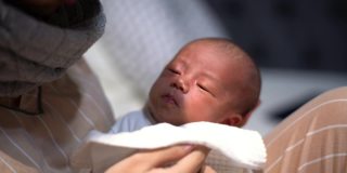 亚洲母亲给婴儿喂奶后打嗝
