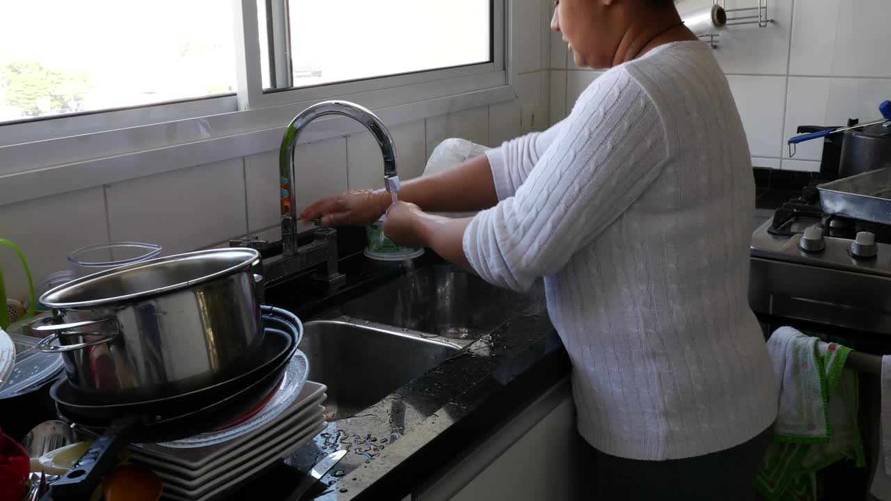 女人在家里洗盘子