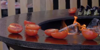 慢镜头:厨师在火盆上用火苗烤香肠和西葫芦
