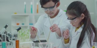 科学实验室里的亚洲孩子们正在学习如何从实验中获得乐趣。用干冰和水混合，产生凉爽的蒸汽