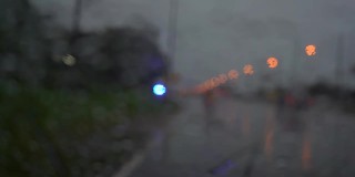 交通汽车运输，夜间公路旅行，雨天。汽车在雨天行驶，雨刮器清洗挡风玻璃上的水。在雨中发生交通事故是危险的。