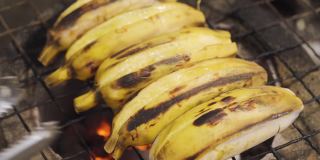 有人在传统的炭炉上烤香蕉皮。烧烤食物。泰国菜。热带地区的甜水果甜点。