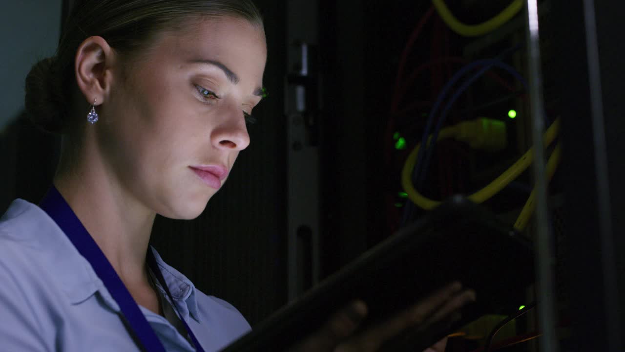 一名年轻女子在服务器室使用数字平板电脑的4k视频片段