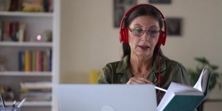 老成熟的女教师在家里用笔记本电脑教在线视频课。网络家教