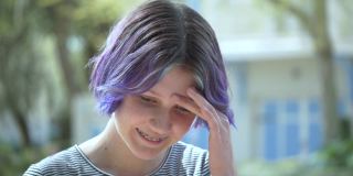 一个紫色头发戴着牙套的少女摇着头