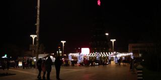 人们走在城市里，12月31日，新年，圣诞节。市中心有一棵大圣诞树，有花环和装饰品。节日心情无雪。散焦