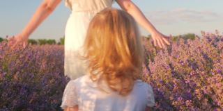 日落时分，母女俩走过一片薰衣草田。热爱自然，香薰，香薰油。自由，幸福，微笑，家人在一起。美丽的花朵。
