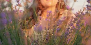 美丽的女人穿着裙子，薰衣草田在日落。热爱自然，香薰，精油。屏幕保护程序,背景,素材。温柔，快乐，幸福。视图通过鲜花