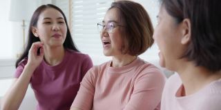 一群亚洲女人坐在一起谈笑风生在粉红戴乳腺癌。