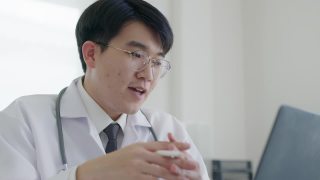 友好的亚洲医生男子视频呼叫在线交谈计算机远程健康。视频素材模板下载
