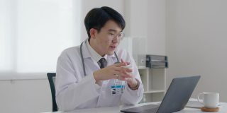 友好的亚洲医生男子视频呼叫在线交谈计算机远程健康。