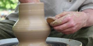 白人种族的男性陶工将一个陶罐与一个木制工具的特写
