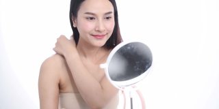 一位亚洲女性博主正在展示如何化妆和使用化妆品。在摄像机前录制视频直播流媒体在工作室