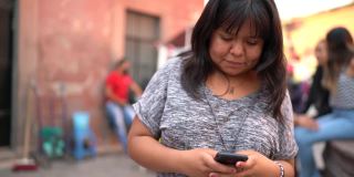 年轻女子使用智能手机走在街上