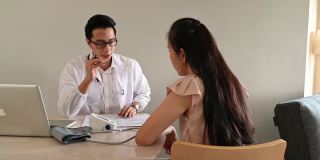 年轻的亚洲男医生正在检查成年女性的血压