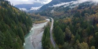 鸟瞰秋天的森林和河流在加拿大山谷与低云