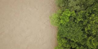 鸟瞰图宽阔的肮脏的河流与泥泞的水在洪水期间在暴雨的春天。