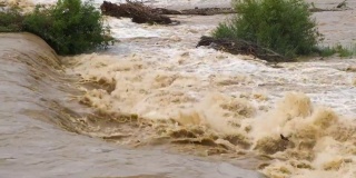 春季暴雨期间洪水泛滥，河水浑浊，河面宽阔。