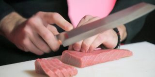厨师用锋利的刀切金枪鱼片做寿司