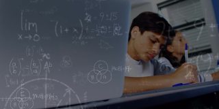 一名小学生在课堂上使用笔记本电脑，数学方程式在男孩身上漂浮