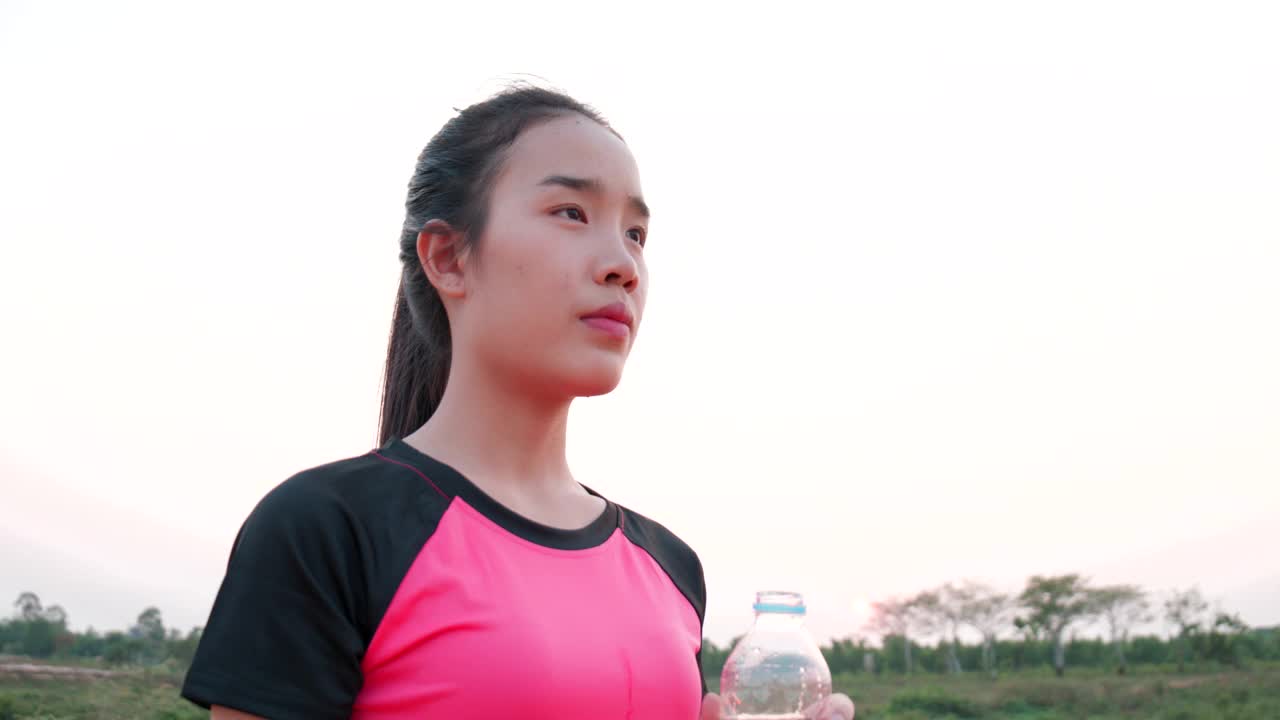 年轻女子在锻炼后喝瓶装水