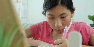 亚洲女孩在Covid-19期间在家学习在线课程，居家隔离生活理念。