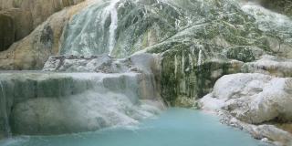 慢镜头:意大利托斯卡纳的地热池和温泉。巴格尼圣菲利波天然热瀑布在早上没有人。森林中的白鲸。