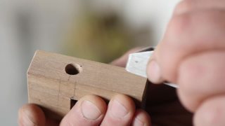 木匠用小刨子刨去一块木头的倒角。木工刨平。手木工工具视频素材模板下载