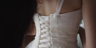 裁缝师正在测量身体的尺寸，然后试穿婚纱。