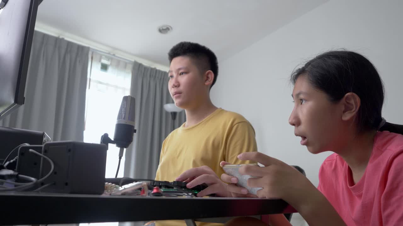 快乐的亚洲孩子们在家里一起玩在线游戏，这是新一代生活方式的时尚活动。