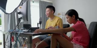 快乐的亚洲孩子们在家里一起玩在线游戏，这是新一代生活方式的时尚活动