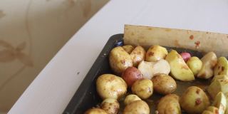 切好的西葫芦、腌料和土豆放在烤盘上。特写镜头。