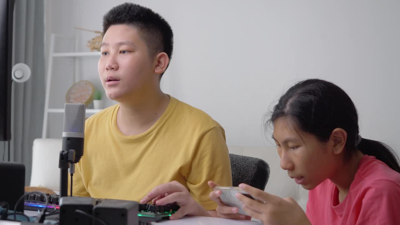 快乐的亚洲孩子们在家里一起玩在线游戏，这是新一代生活方式的时尚活动