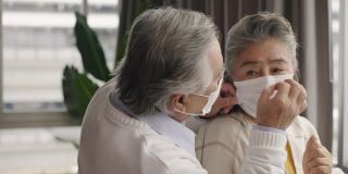 两对戴着口罩的亚洲老人互相拥抱，互相鼓励。
