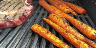 厚切生调味牛肉肋眼牛排和有机胡萝卜与火焰木炭烧烤4K视频