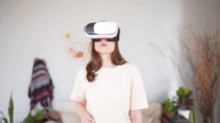 虚拟触觉。在网上购物。年轻女子戴着白色虚拟现实头盔视频素材模板下载
