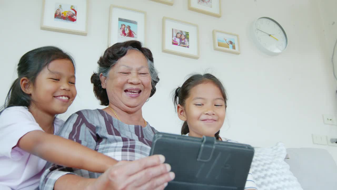 两个孙女一起在客厅里帮奶奶用ipad。