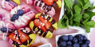 手工制作的精美马卡龙，巧克力装饰的新鲜草莓和蓝莓甜点，精致的黄色和粉色蛋糕，糖和健康食品